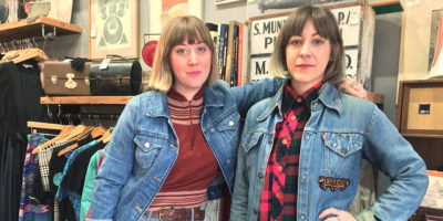  Kate Thomas, left, and Angie Gavin pose inside of their Hampden boutique, Milk and Ice Vintage.Photography by Sydney Adamson